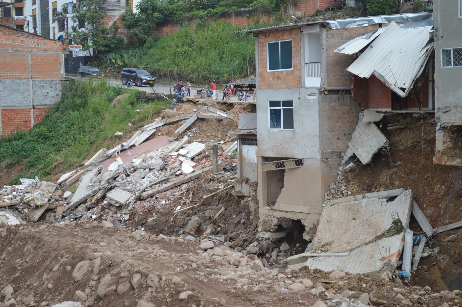 Longsor terbaru 2026 menampilkan lereng tanah yang runtuh, debu tebal, dan area terdampak kerusakan parah.